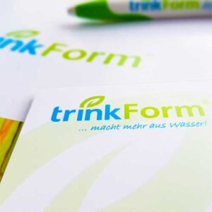 Presse Nahaufnahme des trinkForm® Logos mit dem Slogan "...macht mehr aus Wasser!" als Teil des neuen Designs