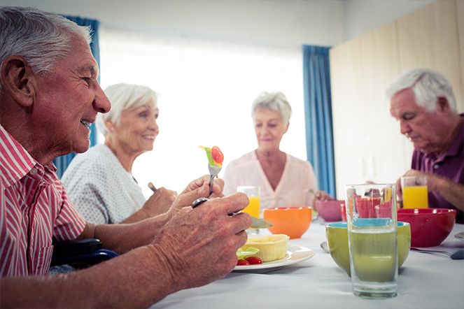Ältere Menschen genießen gemeinsam eine Mahlzeit in einer Senioreneinrichtung