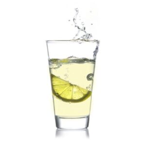 Ein Glas mit trinkForm® Citruskonzentrat und einer dynamisch spritzenden Limettenscheibe, für ein belebendes Geschmackserlebnis